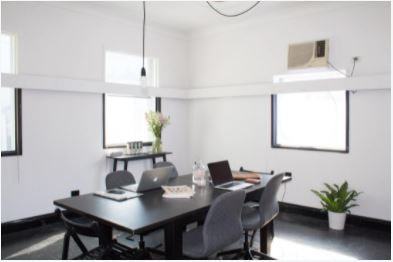 White painted office conference room with black table and gray chairs